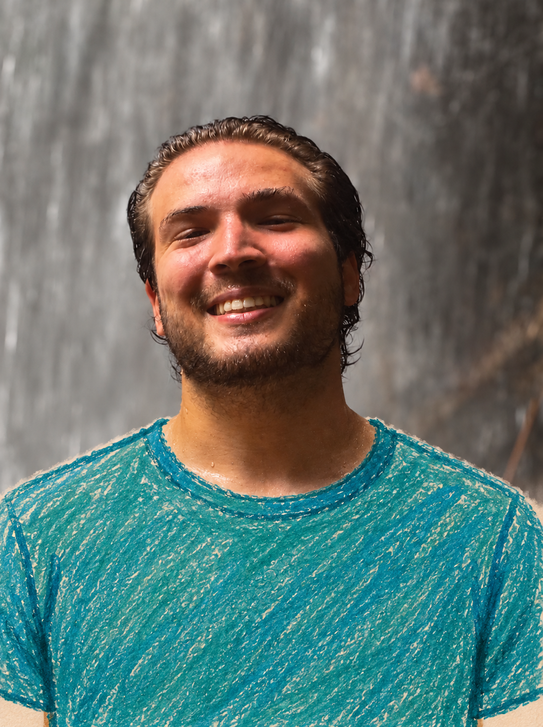 Matheus sorrindo na água, usando uma camisa azul-marinho.